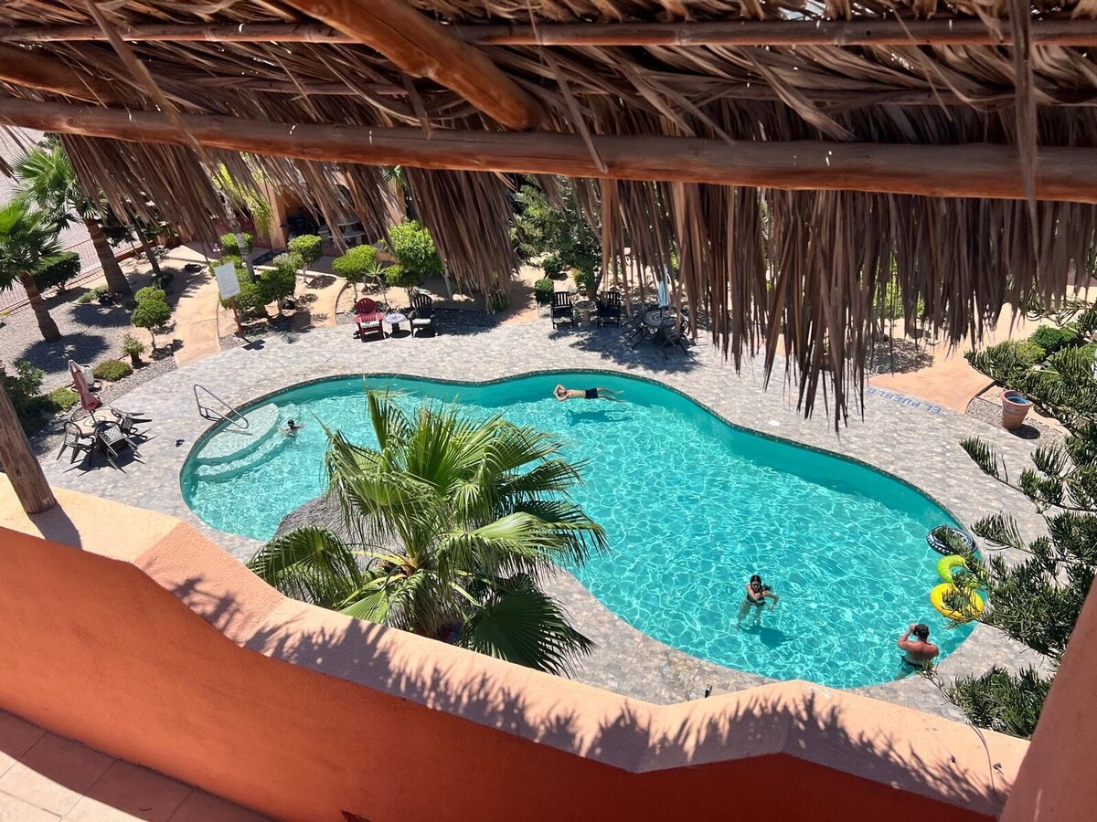 Pool viewed from beneath a rooftop palapa