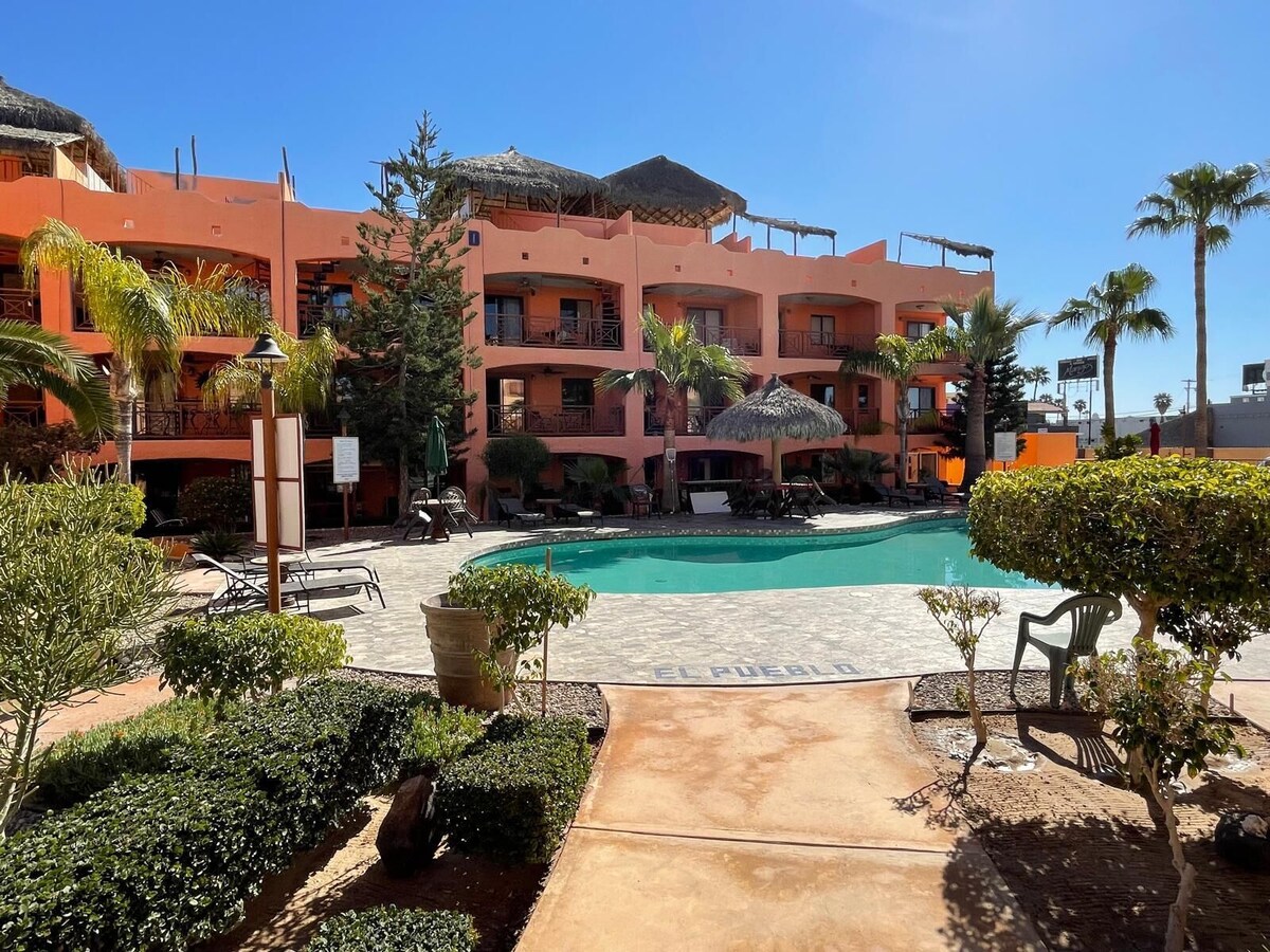 Pool, palms, gardens, and colorful condominiums at El Pueblo