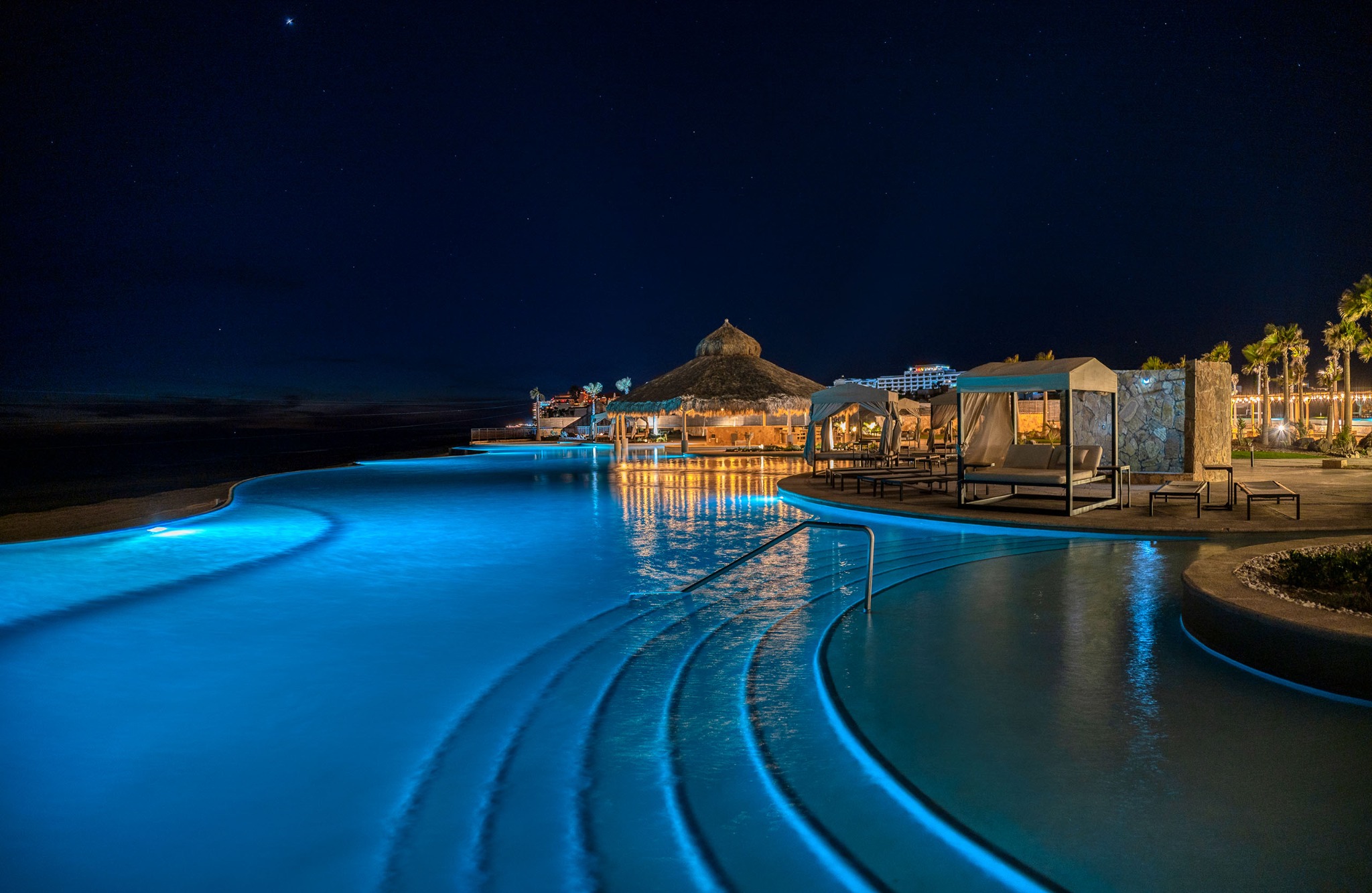 Illuminated beachfront pool at night